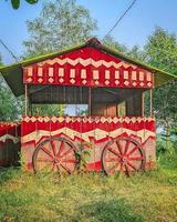 A red and white painted wooden structure with wheels photo