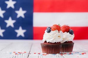 Sweet cupcakes with blueberries and strawberry , flag background photo