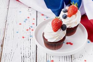 Sweet cupcakes with blueberries and strawberry , flag background photo