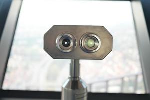 Coin-operated binoculars looking out over city , photo