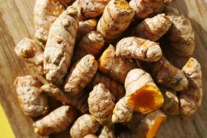 detail shot of turmeric root in bowl on table , photo