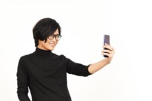 tomar un selfie utilizando teléfono inteligente de hermoso asiático hombre aislado en blanco antecedentes foto