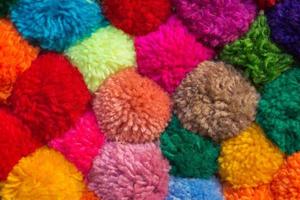 textured background of assorted and multicolored wool pom poms photo