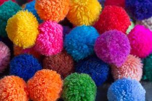 textured background of assorted and multicolored wool pom poms photo