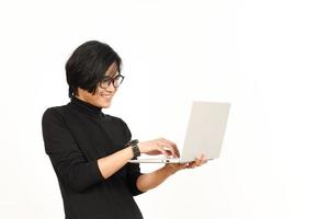 en pie y utilizando ordenador portátil de hermoso asiático hombre aislado en blanco antecedentes foto