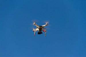 a drone that photographs flying in the blue sky photo