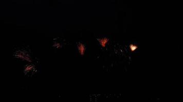 schijnend vuurwerk met bokeh lichten in nacht lucht. gloeiend vuurwerk show. nieuw jaar vooravond vuurwerk viering. vuurwerk in nacht lucht. mooi gekleurde nacht explosies in zwart lucht video