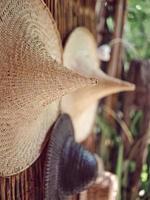 Wicker hats from bamboo hang on the wall. photo