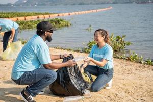 Volunteers cleaning plastic at river beach. Environmental and ecological care, Earth day concept photo