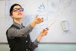 profesor con un puntero cerca el pizarra. profesor de dibujo. foto