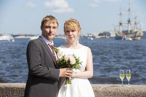 Portrait of the bride and groom on the background of the river photo