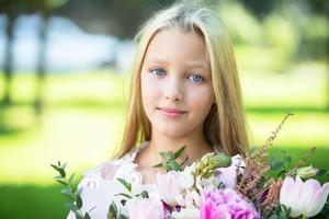 Portrait of a blonde beautiful teenage girl with a bouquet of flowers. photo