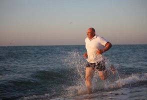 An adult man runs along the coast. photo