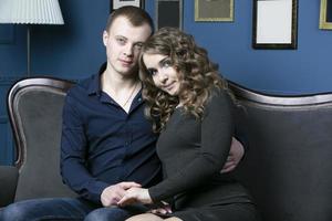 The guy and the girl are sitting embracing. A young couple. Lovers. Portrait of a man and woman. photo