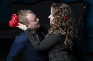 joven Pareja en San Valentín día. amantes niña y chico con un rojo corazón. romántico fecha. foto