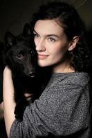 Portrait of a beautiful girl with a black dog.Woman with a shipper. photo