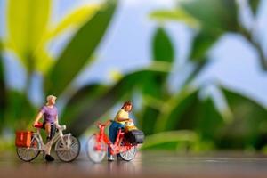 miniatura personas en pie con bicicleta, mundo bicicleta día concepto foto