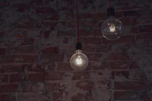 brillante ligero bombillas lamparas en el antecedentes de un ladrillo pared foto