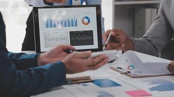 Financial analysts analyze business financial reports on a digital tablet planning investment project during a discussion at a meeting of corporate showing the results of their successful teamwork. video