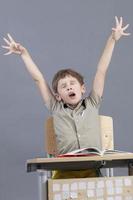 The child yawns in the classroom. Elementary school student wants to sleep in class. photo