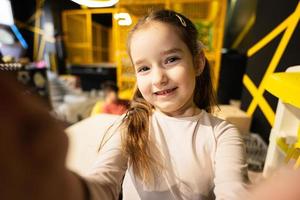 Preschooler girl making selfie at children play center. photo