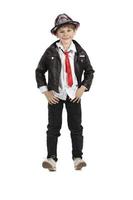 Fashionable boy in eight height on a white background. Child in a hat a leather jacket with a red tie. Funny elementary school student. photo