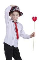 Child with Valentine. The boy in the hat holds a red heart. Beautiful fashionable child. photo