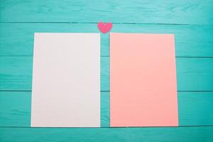 hojas de papel en blanco de color vacías sobre una mesa de madera de cerca foto