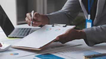 Financial analysts analyze business financial reports on a digital tablet planning investment project during a discussion at a meeting of corporate showing the results of their successful teamwork. video