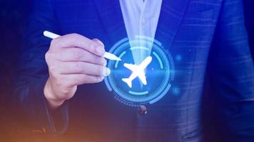 Businessman hand touching an plane airplane icon. Online ticket purchase.Travel icons about travel planning, transportation, flight and passport. Flight ticket booking concept. photo