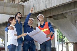 Newly wed couple is meeting with engineering contractor at their under construction house to inspect the building progress and quality control for home ownership and real estate development concept photo