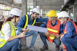 equipo de ingeniero, arquitecto, contratista y capataz reunión y consultante a construcción edificio sitio con piso plan para real inmuebles desarrollo proyecto industria y alojamiento cronograma foto