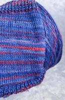 Handmade knitting pattern. Knitted fabric from a multi-colored thread and a large bobbin. photo