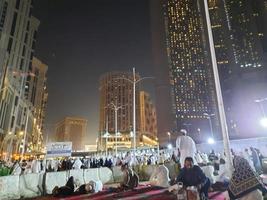 Mecca, Saudi Arabia, April 2023 - A beautiful view of pilgrims, tall buildings and lights at night on the outer road in Masjid al-Haram, Mecca. photo