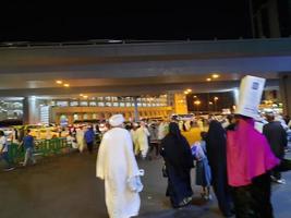 la meca, saudi arabia, abril 2023 - un grande número de peregrinos desde todas terminado el mundo reunir en el exterior la carretera cerca masjid al haram, la meca a noche. foto