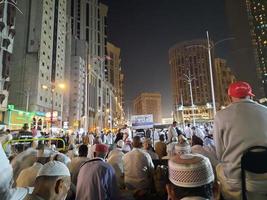 Mecca, Saudi Arabia, April 2023 - A beautiful view of pilgrims, tall buildings and lights at night on the outer road in Masjid al-Haram, Mecca. photo
