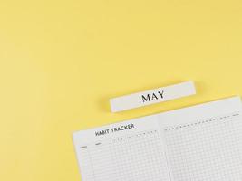 plano diseño de hábito rastreador libro, de madera calendario mayo en amarillo antecedentes con Copiar espacio. foto