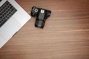 camera and laptop on wooden table photo