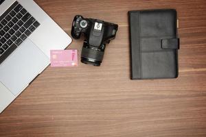 camera and laptop on wooden table photo