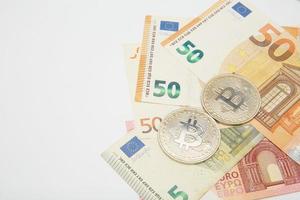 euro and bitcoin banknotes, cryptocurrency and blockchain concept on white background flat lay photo