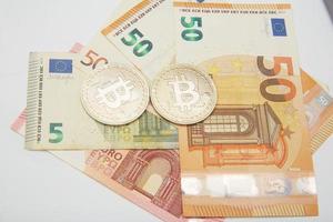 euro y bitcoin billetes de banco, criptomoneda y blockchain concepto en blanco antecedentes plano laico foto