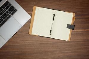 laptop, notepad on wooden table office concept, stationery, flat lay photo