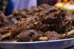 Roasted leg pieces of mutton at a street food market in Dhaka, Bangladesh photo