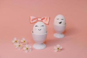 eggs with face and flowers on the pink bow, for Easter background photo