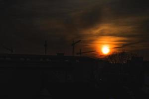 vistoso puesta de sol con rojo cielo y arboles y nubes foto