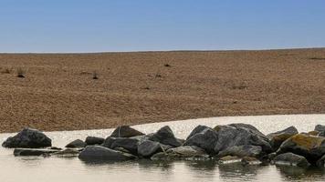 Rock pool on a pebble beach photo