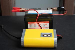 Charging motorcycle battery, battery maintenance and repair concept photo