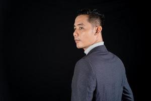Portrait of handsome elegant man in suit on black background. Studio mode portrait photo