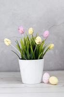 Easter composition with Easter eggs and grass on a gray background photo