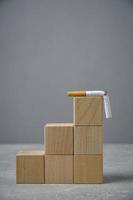There broken cigarette at top of wooden cube ladder.Concept, World no tobacco Day. photo